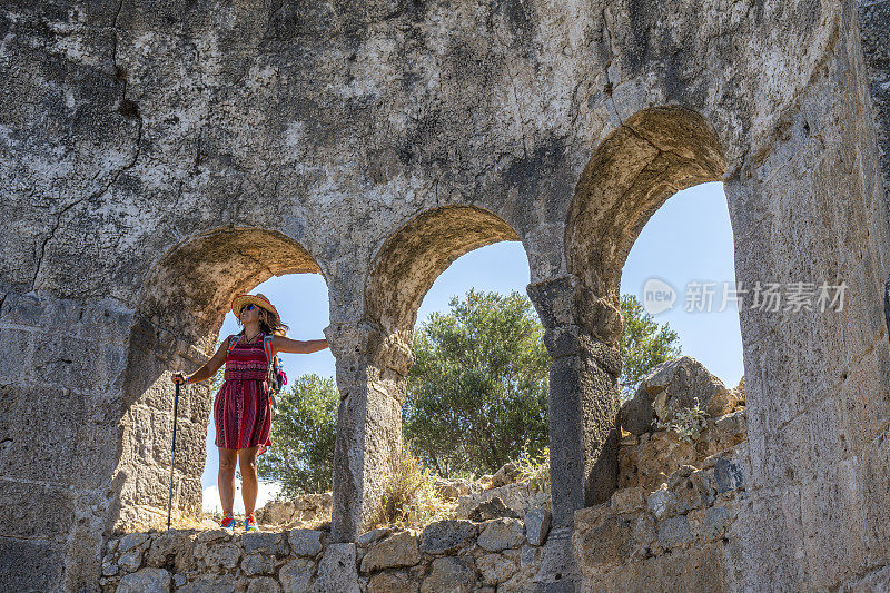 从古老教堂的窗户往外看的女人。来自Ölüdeniz, Fethiye，土耳其。